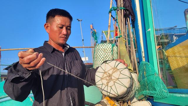 Ngư dân Nguyễn Đức Hưởng buộc phao câu mực, chuẩn bị cho chuyến đánh bắt hải sản.